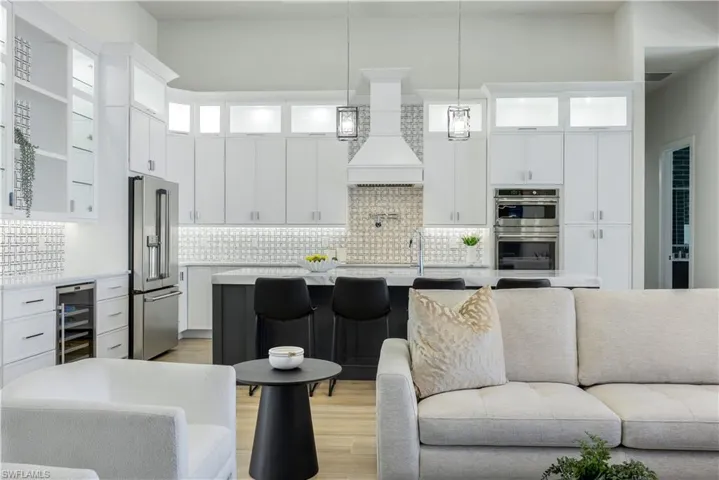 Living area with beverage cooler and light wood-type flooring