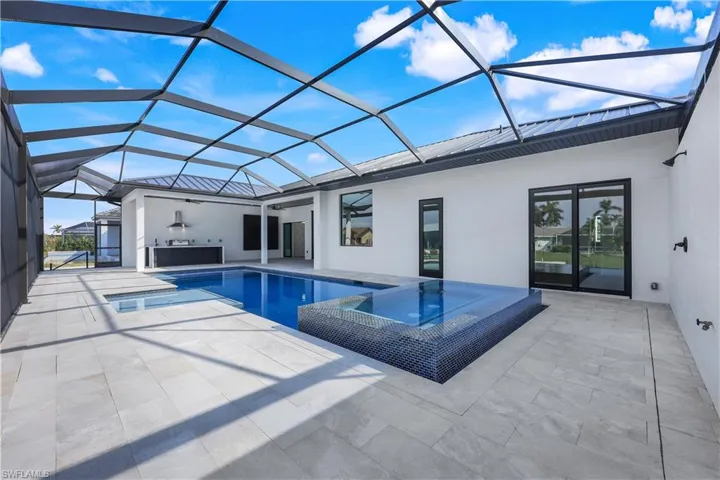 View of pool featuring a pool with connected hot tub, a lanai, and a patio area