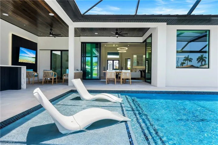 Outdoor pool with a ceiling fan, a patio area, and a lanai