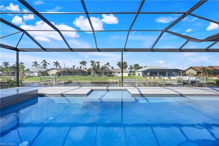 View of swimming pool featuring glass enclosure, a residential view, and a patio