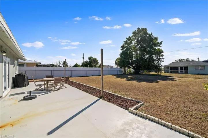 Fenced backyard featuring a patio area, outdoor dining space, and a grill