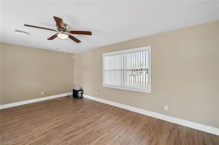 Unfurnished room with wood finished floors and a ceiling fan