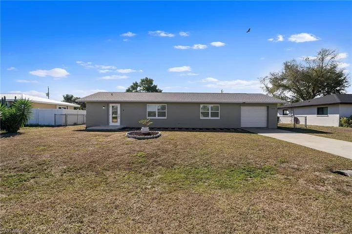 Ranch-style house featuring driveway, stucco siding, and a garage