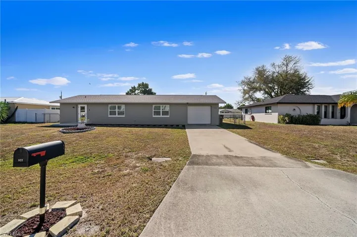 Ranch-style home with concrete driveway, stucco siding, and a garage