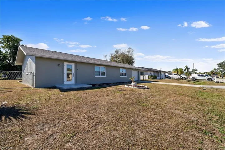 View of front of home with stucco siding, a patio area, and driveway