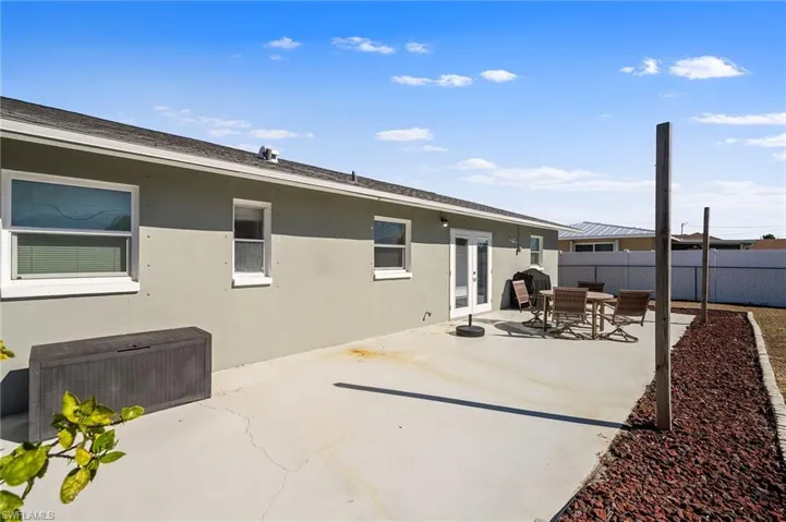 Back of property with a fenced backyard, a patio area, outdoor dining area, stucco siding, and french doors