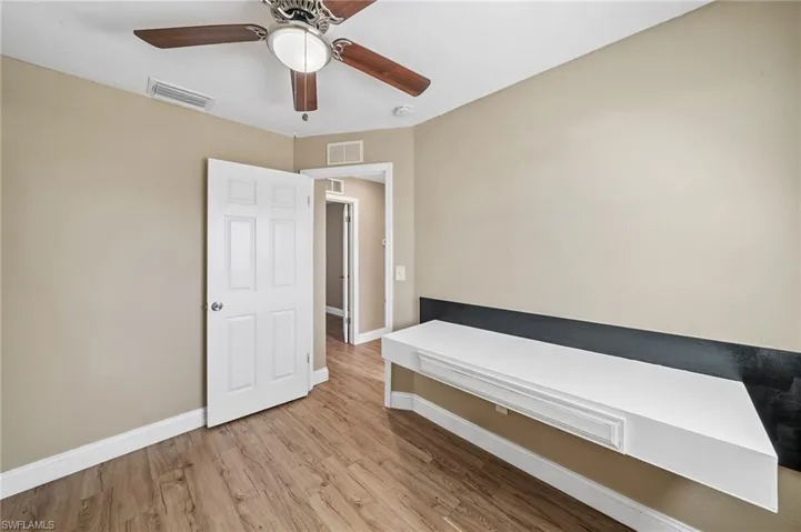 Unfurnished bedroom featuring wood finished floors and a ceiling fan