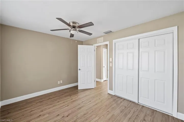 Unfurnished bedroom featuring light wood-style floors, ceiling fan, and a closet