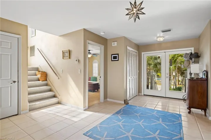 Living room with ceiling fan, high vaulted ceiling, and light wood-type flooring