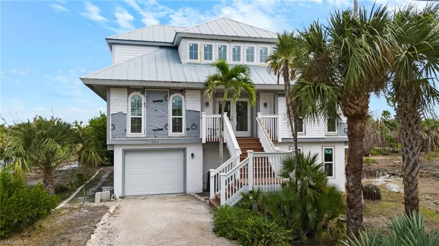 Rear view of property with a yard, a patio area, and a balcony