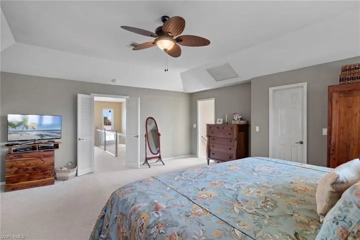 Bathroom featuring vanity, a tub to relax in, tile patterned floors, and vaulted ceiling
