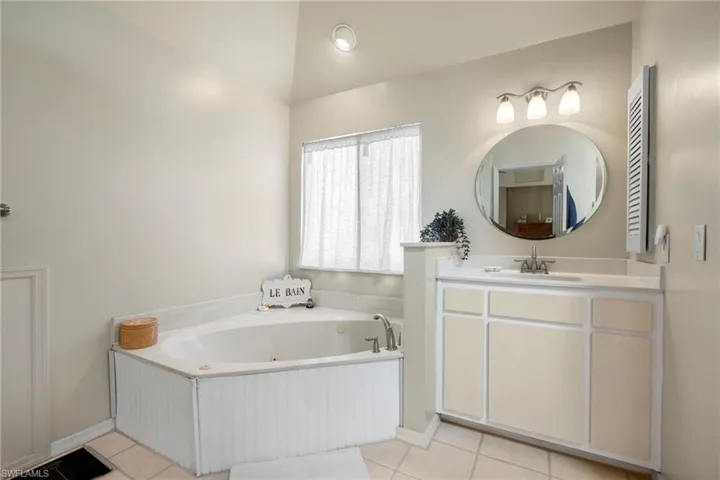 Carpeted bedroom featuring multiple windows and ceiling fan