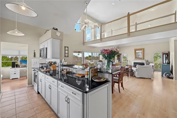 Dining space with a healthy amount of sunlight, high vaulted ceiling, light wood-type flooring, and ceiling fan