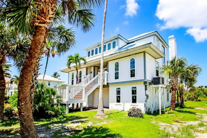 Back of property featuring a lawn