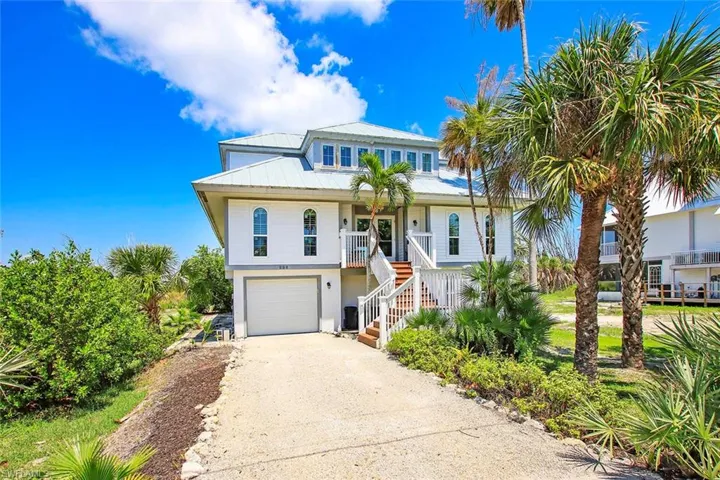 Coastal inspired home featuring covered porch and a garage