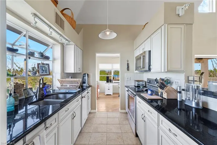 Laundry area with independent washer and dryer and light tile patterned floors