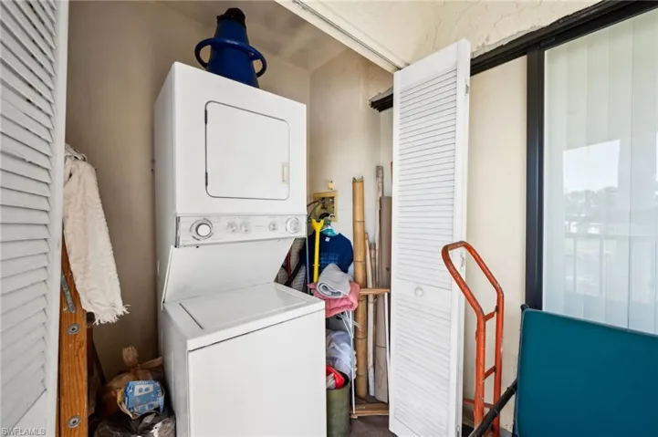 Washroom with laundry area and stacked washer and dryer