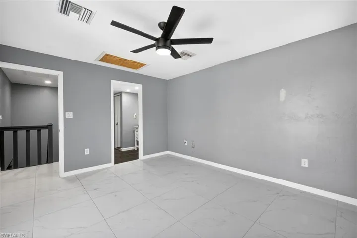 Primary Unfurnished bedroom 1 with a ceiling fan and light marble finish flooring