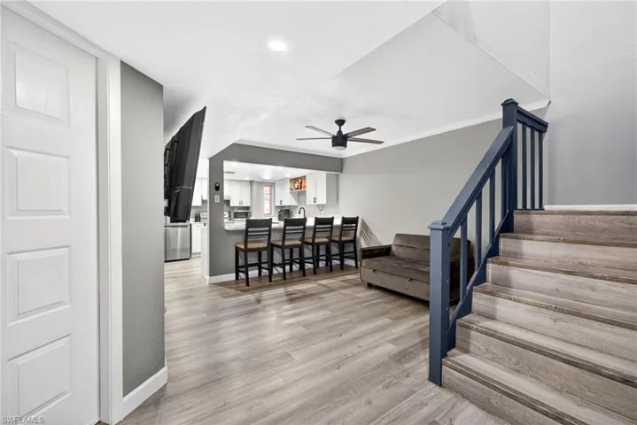 Stairway with wood finished floors, a ceiling fan, and recessed lighting