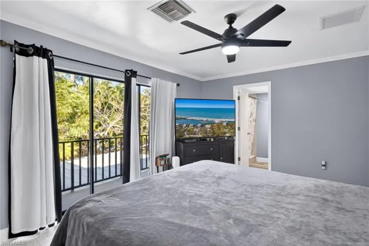 Primary Bedroom 2 featuring ornamental molding, access to exterior, a ceiling fan, and connected bathroom