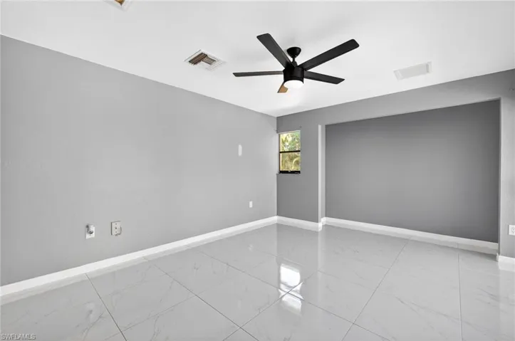 Primary bedroom 1 Unfurnished room featuring ceiling fan and light marble finish flooring