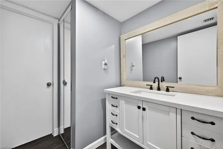Primary Bathroom 1 with vanity and dark wood finished floors