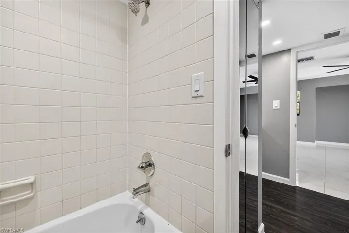 Primary Bathroom 1 featuring recessed lighting, shower / bathtub combination, and wood finished floors