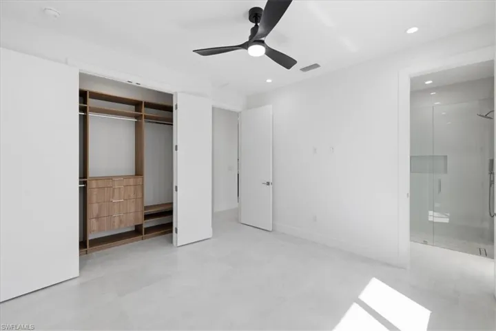 Unfurnished bedroom featuring recessed lighting, a ceiling fan, ensuite bath, and a closet