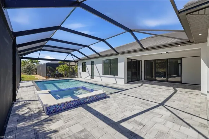 Integrated pool / spa featuring a sunroom, a patio area, and a lanai