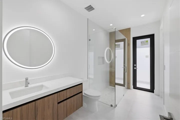 Bathroom with vanity, a walk in shower, and recessed lighting