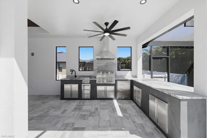 View of patio featuring area for grilling and a ceiling fan