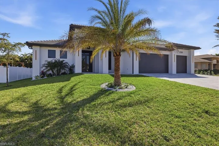 View of front of house featuring driveway, a garage, stucco siding, and a tiled roof