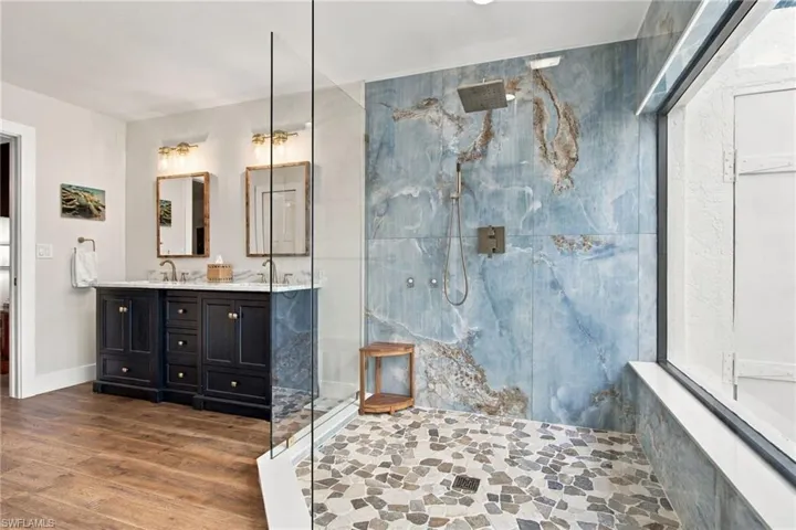 A spa like en suite with a walk-in rain shower, seamless glass and loads of natural light, plus a private water closet and direct access to a secluded patio.