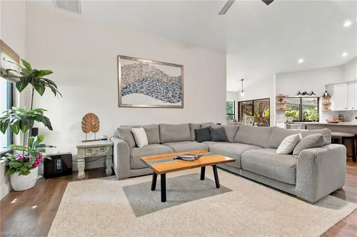 From the kitchen, the second living area opens up beneath high vaulted ceilings that create an airy sense of volume. It's a warm, inviting space that feels both expansive and comfortable.