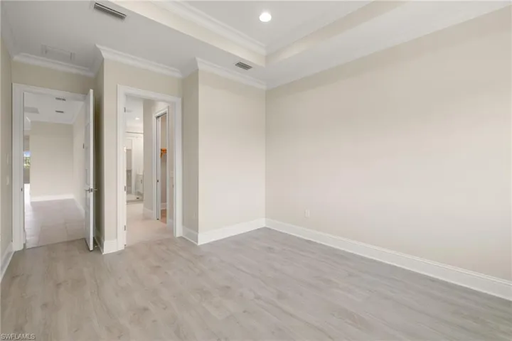 Primary bedroom featuring his & hers walk-in closets, bathroom with frameless shower & his & her dual vanities