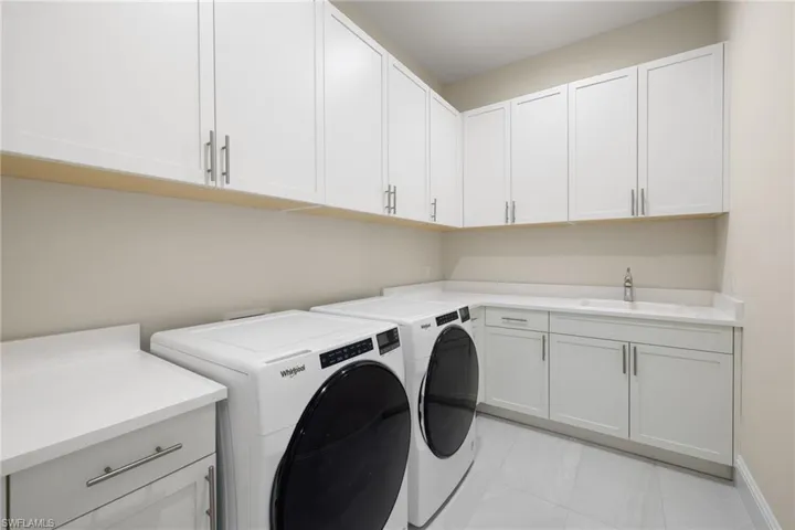 Laundry room with utility sink, plentiful cabinetry & storage