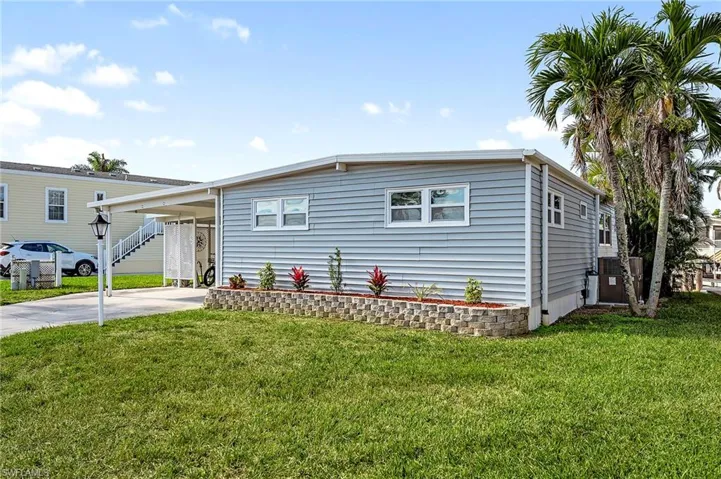 Manufactured / mobile home with a carport, a front yard, and central air condition unit