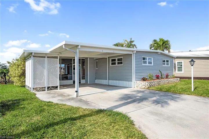 View of front of home featuring a carport and a front yard
