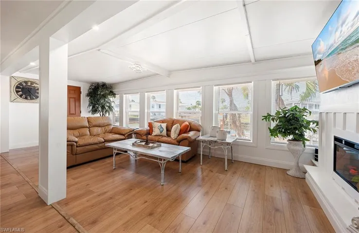 Living room featuring vaulted ceiling with beams and light hardwood / wood-style floors
