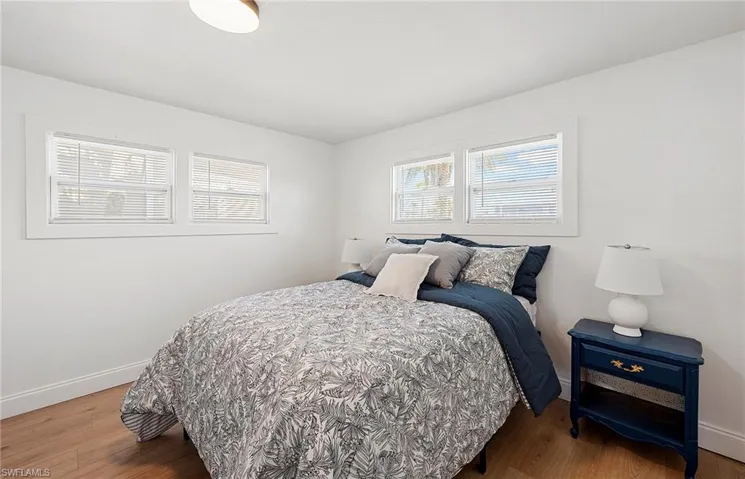 Bedroom featuring multiple windows and hardwood / wood-style flooring