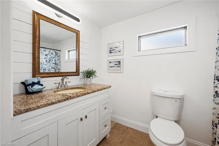 Bathroom with vanity, tile patterned floors, and toilet