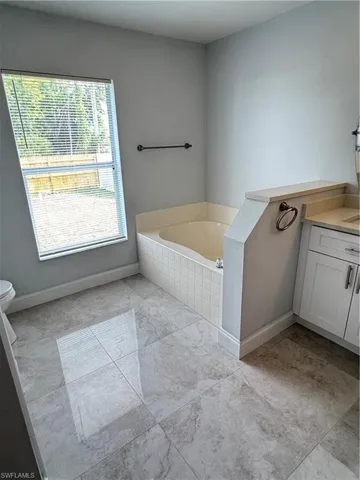 Full bath featuring vanity and a garden tub