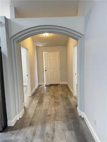 Entryway featuring arched walkways and hardwood / wood-style flooring
