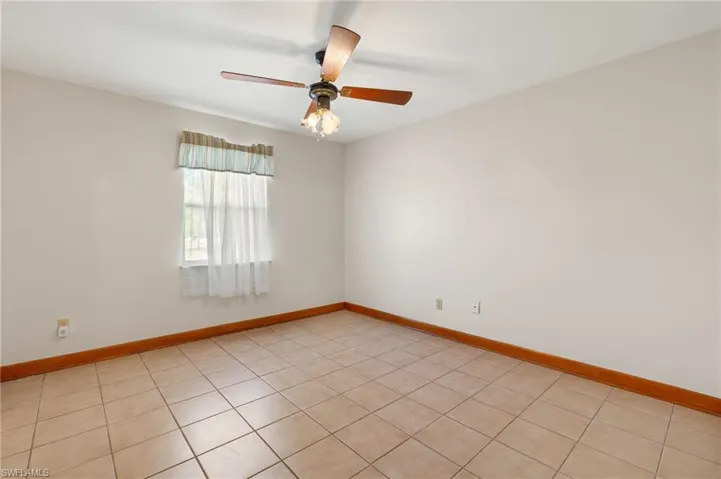 Unfurnished room featuring ceiling fan and light tile flooring