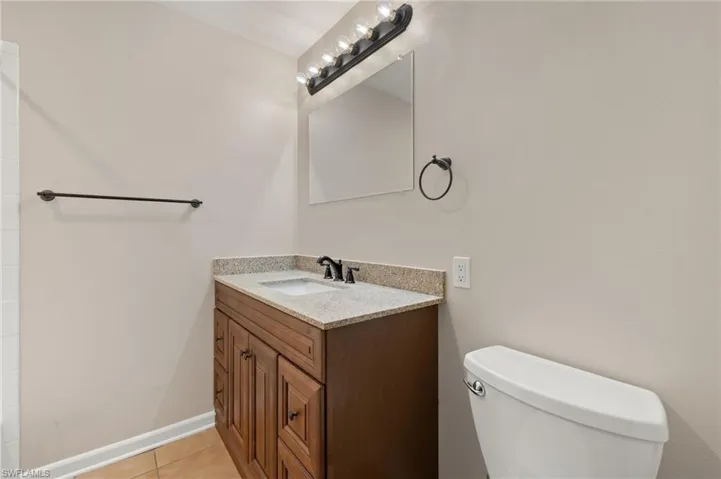 Bathroom featuring vanity, toilet, and tile floors