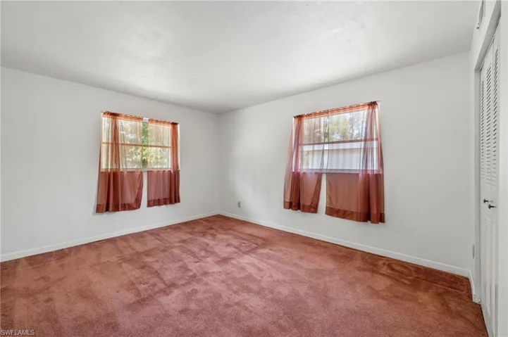 Empty room featuring a wealth of natural light and carpet flooring