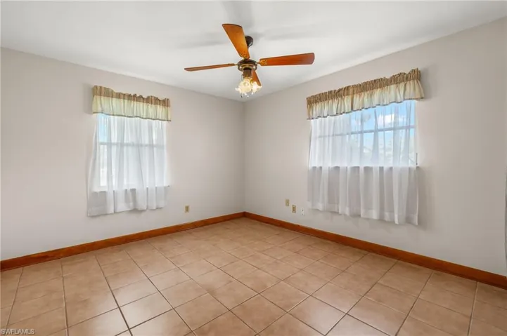 Tiled spare room with ceiling fan