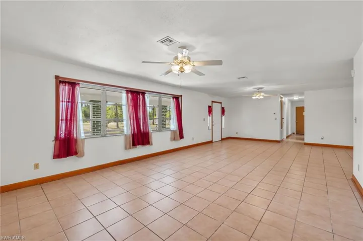 Tiled spare room featuring ceiling fan