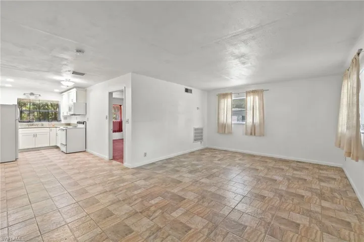 Unfurnished living room featuring sink and light tile flooring
