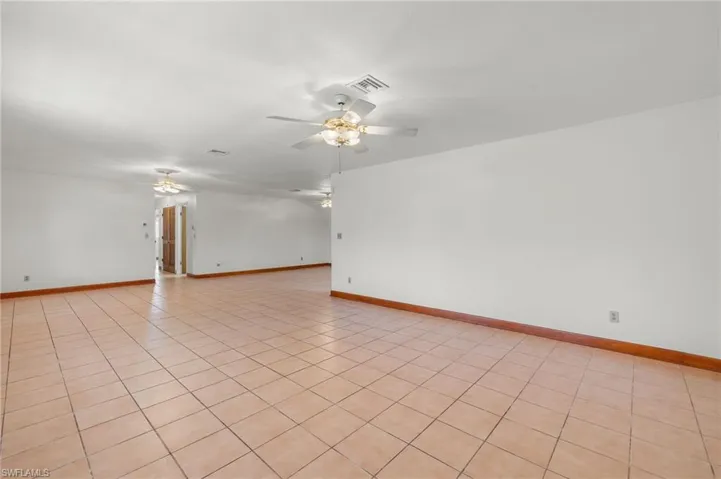 Tiled spare room featuring ceiling fan
